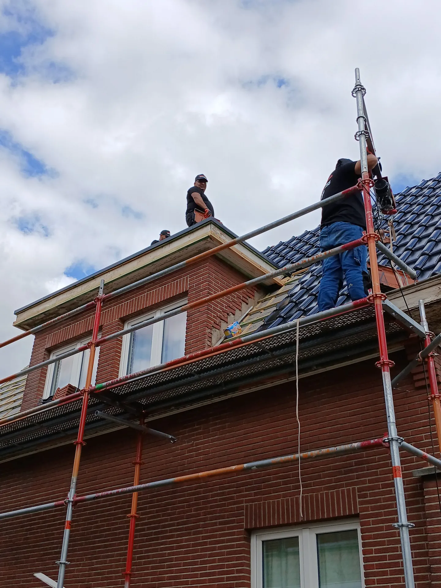 Dakwerker op steiger tijdens dakrenovatie